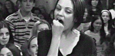 Mila Kunis fits her entire fist into her mouth