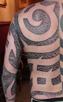 Negative Tribal Back Tattoo